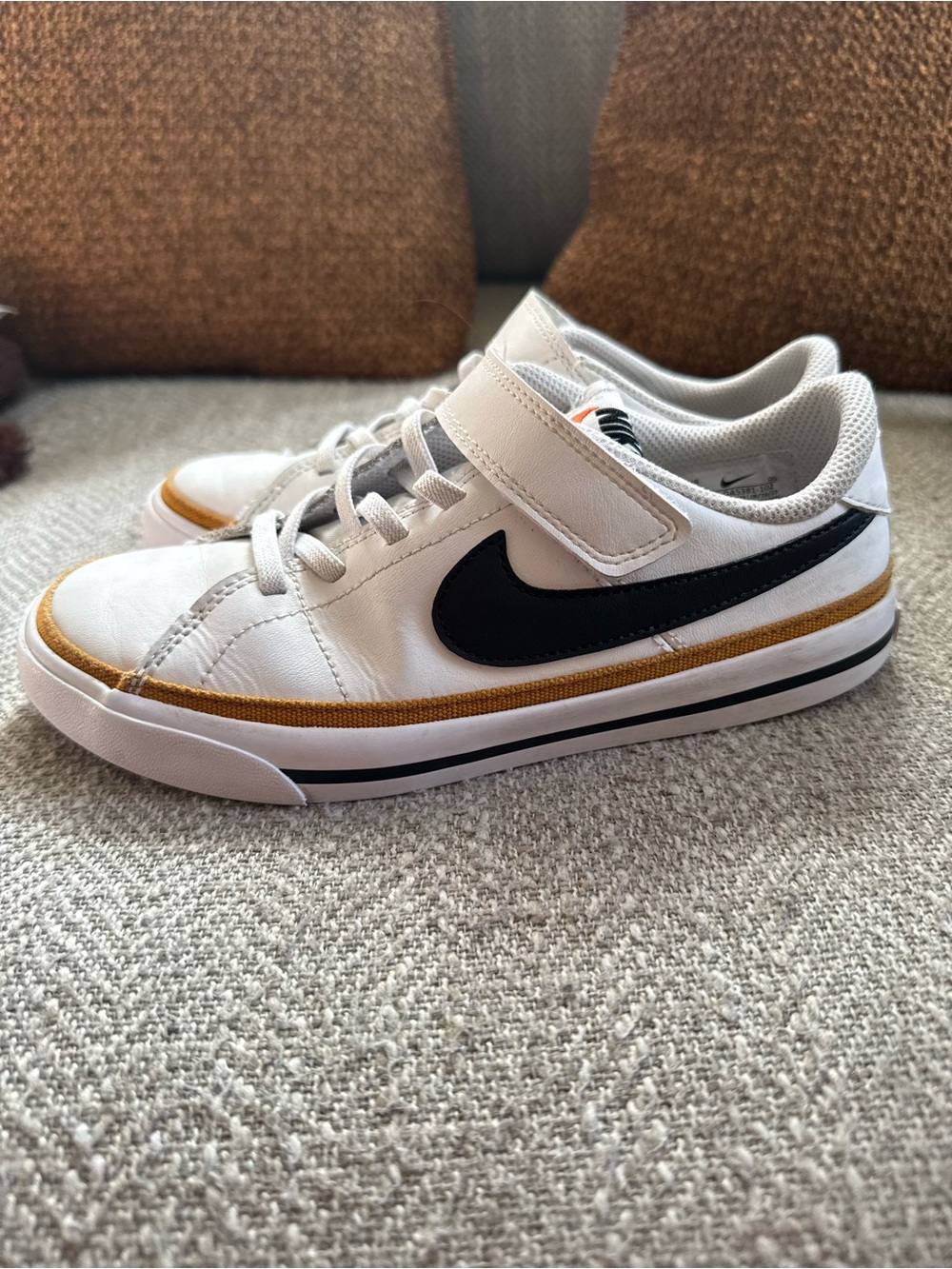 Nike Kids White Sneakers with Black Swoosh and Gold Accent